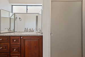 Bathroom featuring double vanity and a shower