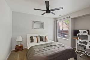 Bedroom with carpet floors, ceiling fan, and a desk