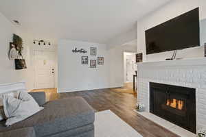 Living area with a brick fireplace and wood finished floors