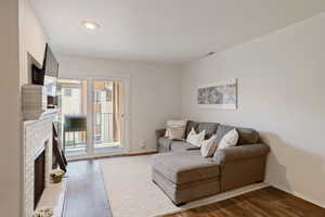 Living room featuring a fireplace, wood finished floors, and recessed lighting