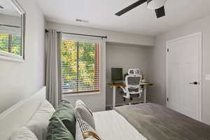 Bedroom with multiple windows and a ceiling fan