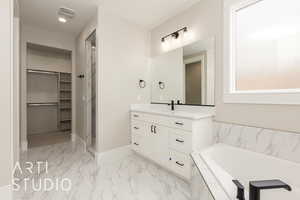 Bathroom featuring a spacious closet, vanity, marble finish flooring, a bath, and a stall shower
