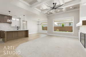 Kitchen with light countertops, a sink, a fireplace, baseboards, and backsplash