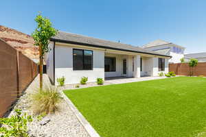 Back of property with stucco siding, a patio area, and a shingled roof