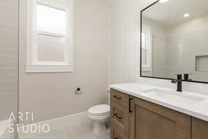 Bathroom featuring vanity, tile patterned floors, toilet, and baseboards