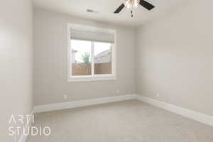 Carpeted spare room featuring a ceiling fan and baseboards