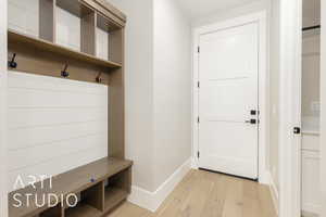 Mudroom with light wood-style floors and baseboards
