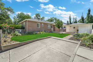 Back of house featuring off street parking, yard, shed, garden area