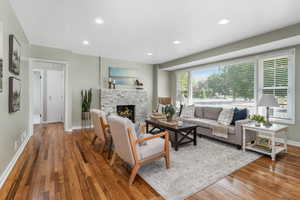 Living room with hardwood / wood-style floors, a fireplace, and recessed lighting