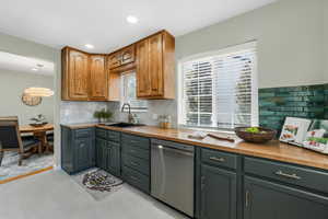 Kitchen featuring dishwasher, backsplash, recessed lighting, and wood counters