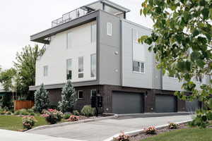 View of front facade featuring stucco siding, brick siding, and a garage