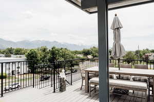 Wooden terrace featuring a mountain view and outdoor dining area