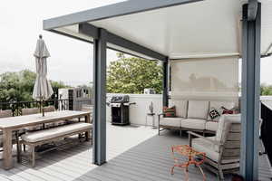 Wooden terrace with area for grilling, outdoor lounge area, and outdoor dining area
