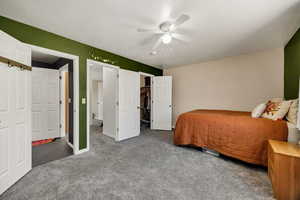 Bedroom with carpet floors, a walk in closet, and ceiling fan