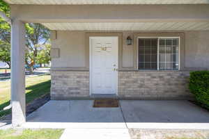 View of exterior entry featuring brick siding and stucco siding
