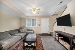 Living room with carpet and a ceiling fan