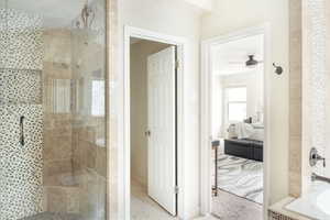 Full bathroom featuring ensuite bathroom, a tile shower, ceiling fan, and a bath