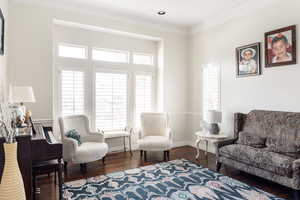 Sitting room featuring ornamental molding, wood finished floors, and baseboards