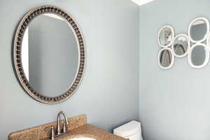 Bathroom with toilet, vanity, and ornamental molding