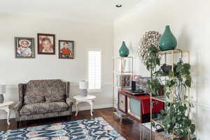 Sitting room with ornamental molding, hardwood / wood-style flooring, a desk, and baseboards