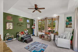 Sitting room with ceiling fan, carpet flooring, a tray ceiling, and recessed lighting