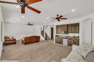 Living area with stairs, ceiling fan, recessed lighting, and light carpet