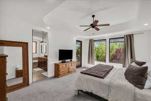 Carpeted bedroom featuring recessed lighting, a tray ceiling, connected bathroom, and ceiling fan