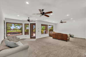 Living room featuring recessed lighting, light colored carpet, and ceiling fan