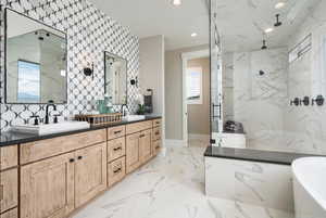 Bathroom featuring a marble finish shower, double vanity, a freestanding tub, recessed lighting, and marble finish floors