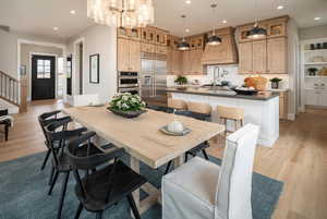 Dining room featuring light wood-type flooring, recessed lighting, a chandelier, and stairs