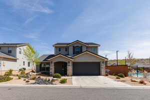 Traditional-style home featuring stucco siding, concrete driveway, a garage, and stone siding