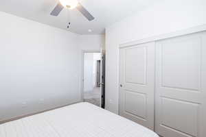Bedroom with a closet, carpet flooring, and a ceiling fan