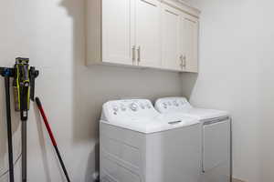 Laundry area featuring cabinet space and washing machine and dryer