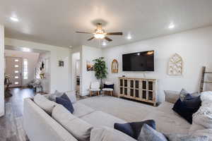 Living area featuring wood finished floors, ceiling fan, and recessed lighting