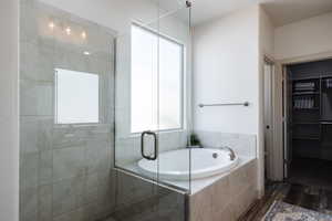 Full bath featuring wood finished floors, a bath, and a stall shower