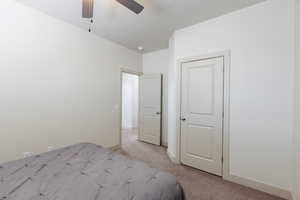 Unfurnished bedroom featuring light colored carpet and ceiling fan