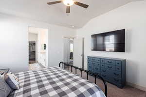 Bedroom with lofted ceiling, light carpet, ceiling fan, and ensuite bath