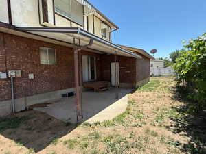 Rear view of property with a patio and brick siding