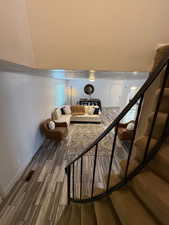 Living area featuring wood finished floors, stairway, and baseboards