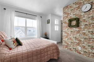 Bedroom featuring light colored carpet, multiple windows, and a textured ceiling