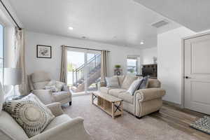 Living area featuring recessed lighting, a textured ceiling, and wood finished floors