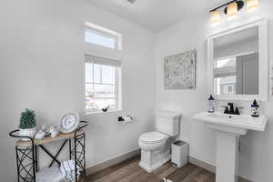Half bath featuring toilet and wood finished floors