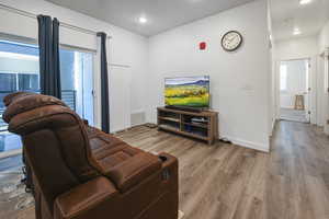 Living area featuring wood finished floors and recessed lighting