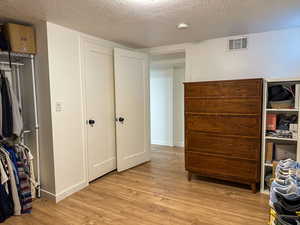 Bedroom featuring light wood-style floors and a textured ceiling