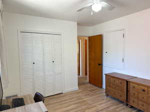 Office area featuring light wood-style floors and ceiling fan