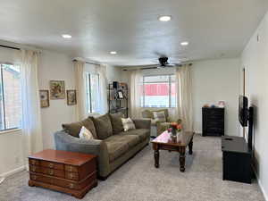Living area with light carpet, ceiling fan, and recessed lighting