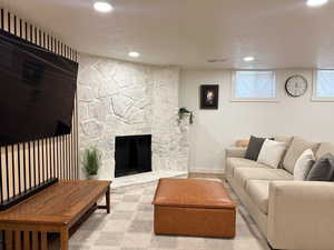 Living area with recessed lighting, a textured ceiling, a fireplace, and carpet flooring