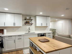 Kitchen featuring butcher block countertops, stainless steel appliances, open shelves, white cabinetry, and recessed lighting