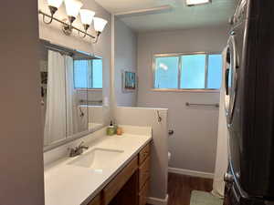 Full bath featuring wood finished floors, vanity, and a shower with curtain