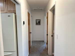 Hallway featuring carpet flooring and attic access